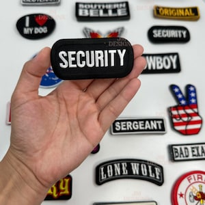 May include: A collection of embroidered iron-on patches with various designs and text, including "Security", "Old Skool", "Southern Belle", "Lone Wolf", "Bad Example", "Cowboy", "Sergeant", "Original", "Route 66", and "Fire Department".