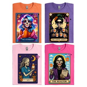 May include: Four colorful t-shirts with unique designs. The shirts are orange, purple, pink, and magenta. Each shirt features a tarot card-style illustration with a skeleton figure representing different professions. Text on the shirts includes "THE HOMEBODY", "THE COFFEE ADDICT", "THE PHARMACY TECH", and "THE REALTOR".