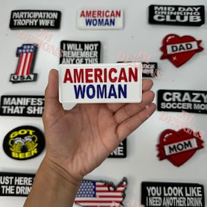 Könnte beinhalten: Eine Sammlung von Bügelbildern mit verschiedenen Designs und Sprüchen, darunter "American Woman", "Crazy Soccer Mom", "Mid Day Drinking Club", "You Look Like I Need Another Drink" und "Participation Trophy Wife".