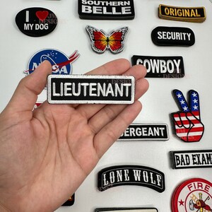 Puede incluir: Una colección de parches bordados para planchar con varios diseños y frases, incluyendo "Old Skool", "Lieutenant", "I Love My Dog", "Southern Belle", "Sexy", "Bad Example", "Original", "Security", "Cowboy", "Lone Wolf", "Route 66" y "Fire Department".