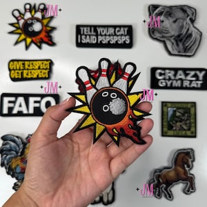 Pode incluir: Uma coleção de patches bordados com vários designs. Um patch apresenta uma bola de boliche e pinos com chamas. Outros patches incluem texto como "GIVE RESPECT GET RESPECT" e "TELL YOUR CAT I SAID PSPSPSPS".