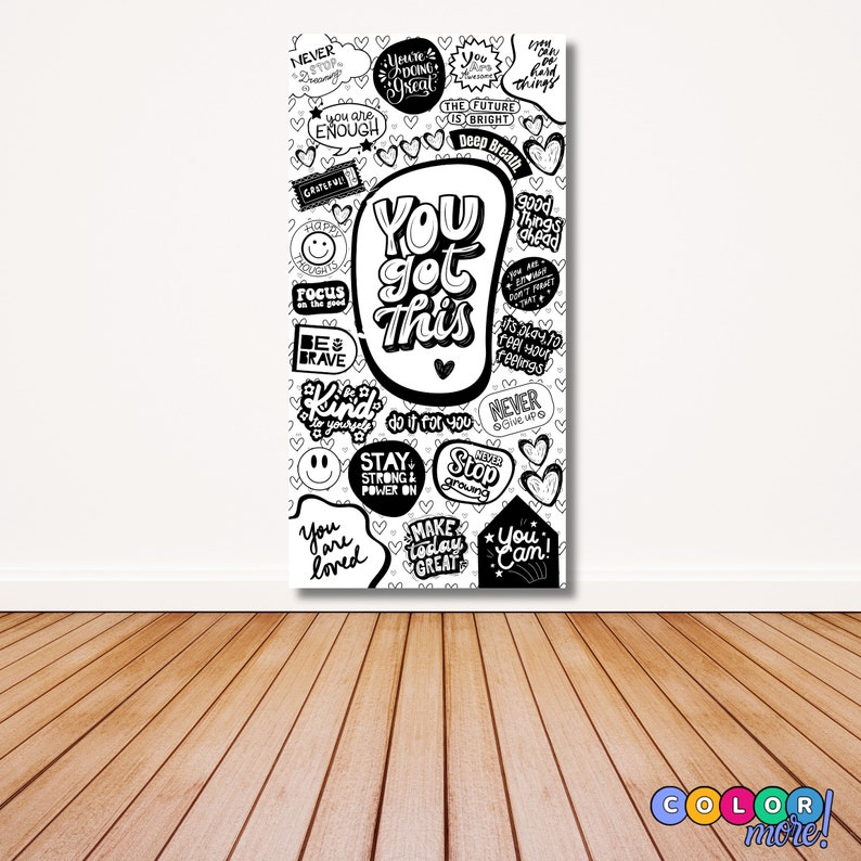 Puede incluir: Arte en lienzo en blanco y negro con frases motivadoras. El texto central dice "You Got This", rodeado de otras afirmaciones positivas como "Be Brave", "Never Give Up" y "You Are Enough". La obra de arte se exhibe en una pared con suelo de madera.