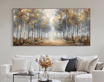 May include: A large rectangular painting depicts a forest scene with tall, slender trees. The artwork features a palette of gold, gray, and brown tones, creating a serene and atmospheric landscape. The painting is displayed above a white sofa.