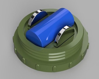 May include: A close-up of a green and blue object. The object has a cylindrical blue center with two silver handles. The base is a circular green with a ridged edge. The object is set against a gray background.