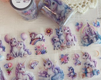 May include: Two rolls of decorative tape and several unicorn stickers. The tape features a unicorn design with a floral background. The stickers depict unicorns, rainbows, and castles. The text on the tape reads "Unicorn Sparkle by Moondreamer Studio".