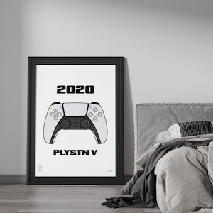 May include: A black framed poster with a white background featuring a white and black illustration of a video game controller. The text "2020" and "PLYSTN V" is printed in black on the poster.
