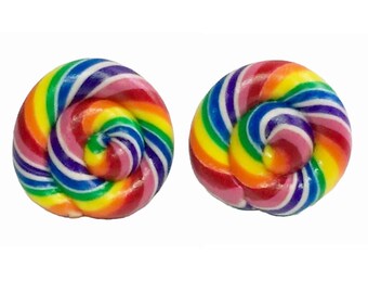 Könnte beinhalten: Zwei Ohrringe in Form von bunten Lollis. Jeder Ohrring zeigt ein Regenbogenmuster mit Farben wie Rot, Orange, Gelb, Grün, Blau, Lila und Rosa in einem spiralförmigen Design. Der Hintergrund ist weiß.