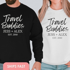 May include: Two black and white sweatshirts with the text "Travel Buddies Jess + Alex Est. 2010" on the front.