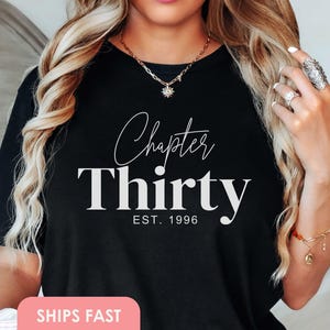 Puede incluir: Camiseta negra con las palabras "Chapter Thirty" en escritura blanca y fuente de bloque, con "EST. 1996" debajo. La camiseta es de cuello redondo.