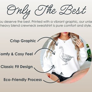 May include: White unisex sweatshirt with a black and white graphic of a goose. The sweatshirt is described as "Crisp Graphic", "Comfy & Cosy Feel", "Classic Fit Design", and "Eco-Friendly Process".