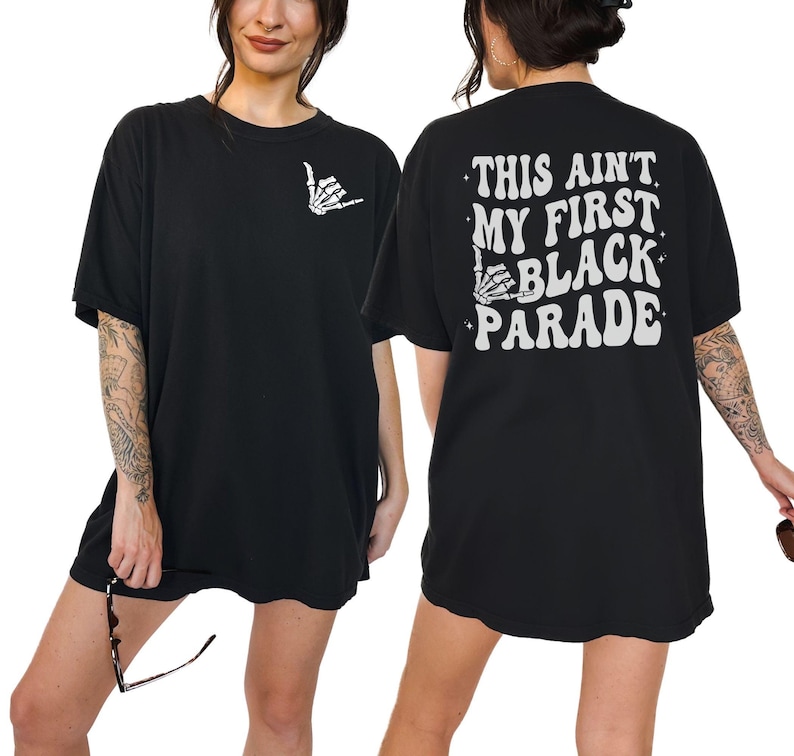 May include: Black oversized t-shirt with the text "This ain't my first Black Parade" in white with a skeleton hand graphic.