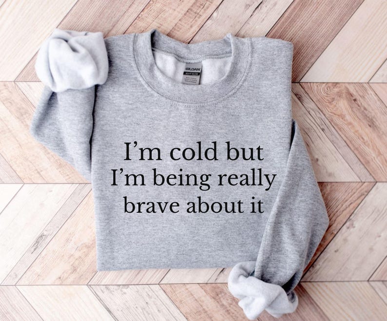 May include: Gray sweatshirt with the text "I'm cold but I'm being really brave about it" printed on the front.