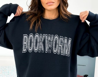 May include: A black sweatshirt with the word "BOOKWORM" printed in a distressed white font.