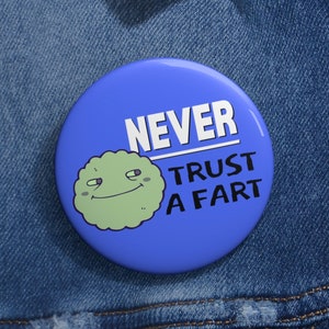 May include: A blue button with a green cartoon face and the text "NEVER TRUST A FART".