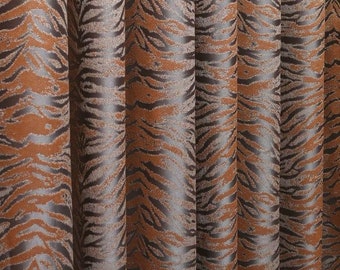 Pode incluir: Um tecido de cortina com um padrão repetitivo de riscas de tigre em tons de castanho escuro e cobre metálico. O material tem uma superfície texturada com pregas verticais que criam sombras e reflexos profundos no tecido.