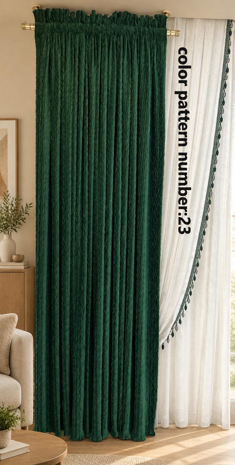 May include: A dark green curtain with a textured, pleated surface hangs from a gold rod next to a sheer white curtain featuring a decorative green pom-pom trim. The text colour pattern number:23 is printed vertically on the white curtain.