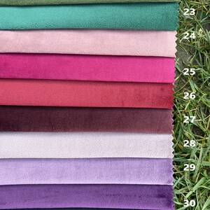 May include: A stack of ten rectangular fabric swatches with a soft, velvet-like texture, arranged in a vertical column. The colours include olive, teal, light pink, magenta, red, burgundy, pale lilac, lavender, purple, and dark navy. Each swatch is numbered 22 through 31.