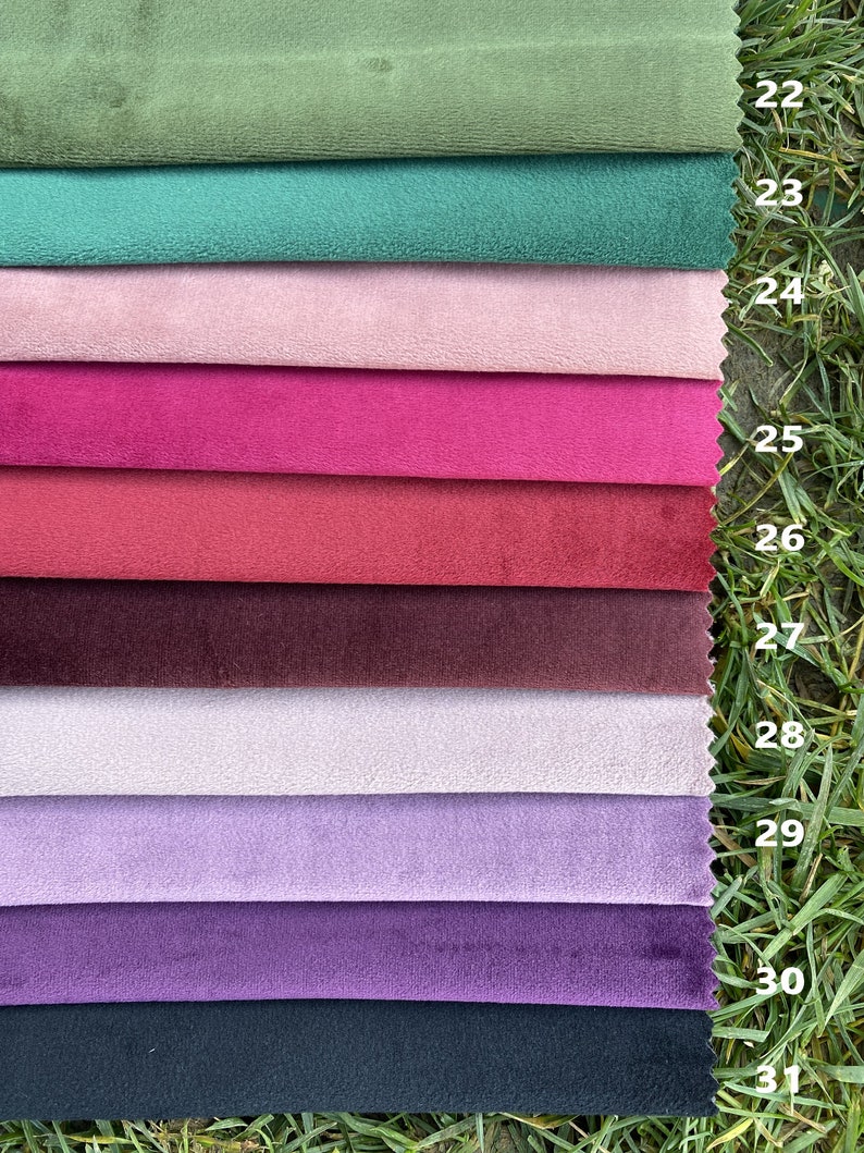May include: A stack of ten rectangular fabric swatches with a soft, velvet-like texture, arranged in a vertical column. The colours include olive, teal, light pink, magenta, red, burgundy, pale lilac, lavender, purple, and dark navy. Each swatch is numbered 22 through 31.