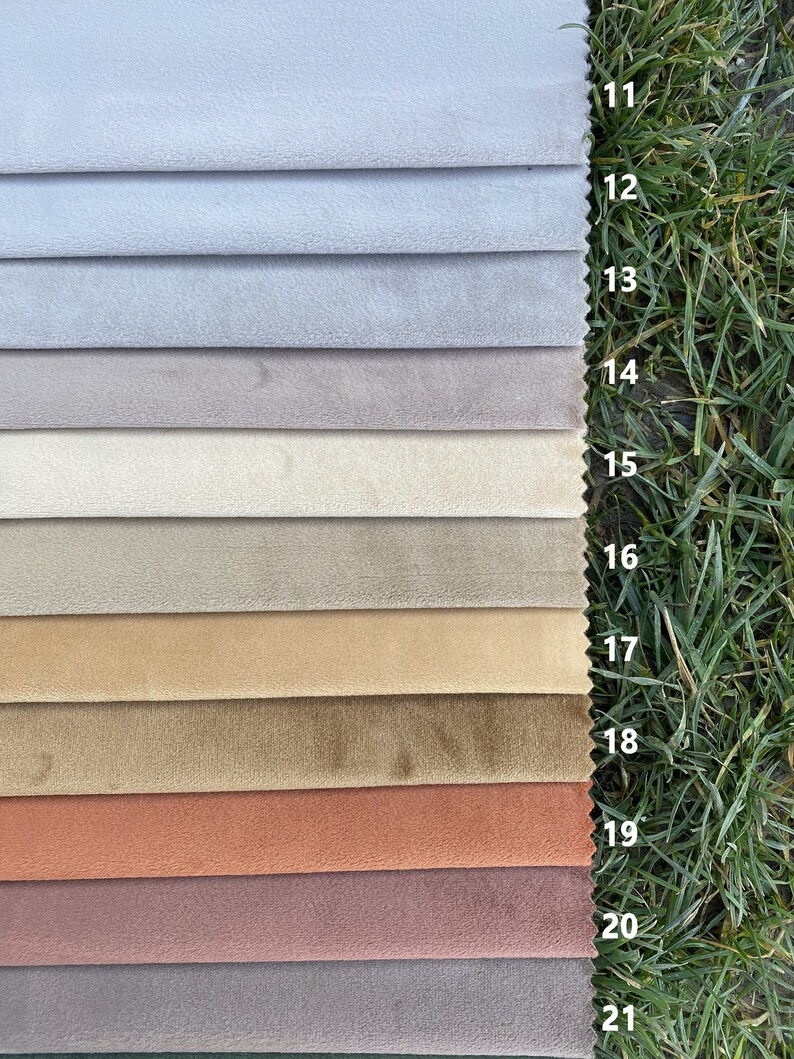 May include: A fabric swatch sample set featuring eleven horizontal strips of velvet-like material in a gradient of colours ranging from light grey to beige, tan, brown, terracotta, and mauve, each labelled with numbers 11 through 21.