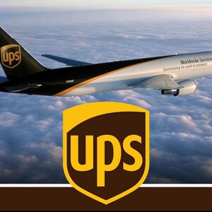 May include: A UPS cargo aeroplane flying above clouds with a black tail featuring the brown and gold UPS shield logo. The white fuselage displays the text Worldwide Services Synchronizing the world of commerce and a large UPS shield logo.