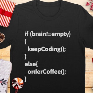 Könnte beinhalten: Schwarzes T-Shirt mit weißem Text, der lautet: "if (brain!=empty) { keepCoding(); } else{ orderCoffee(); }"