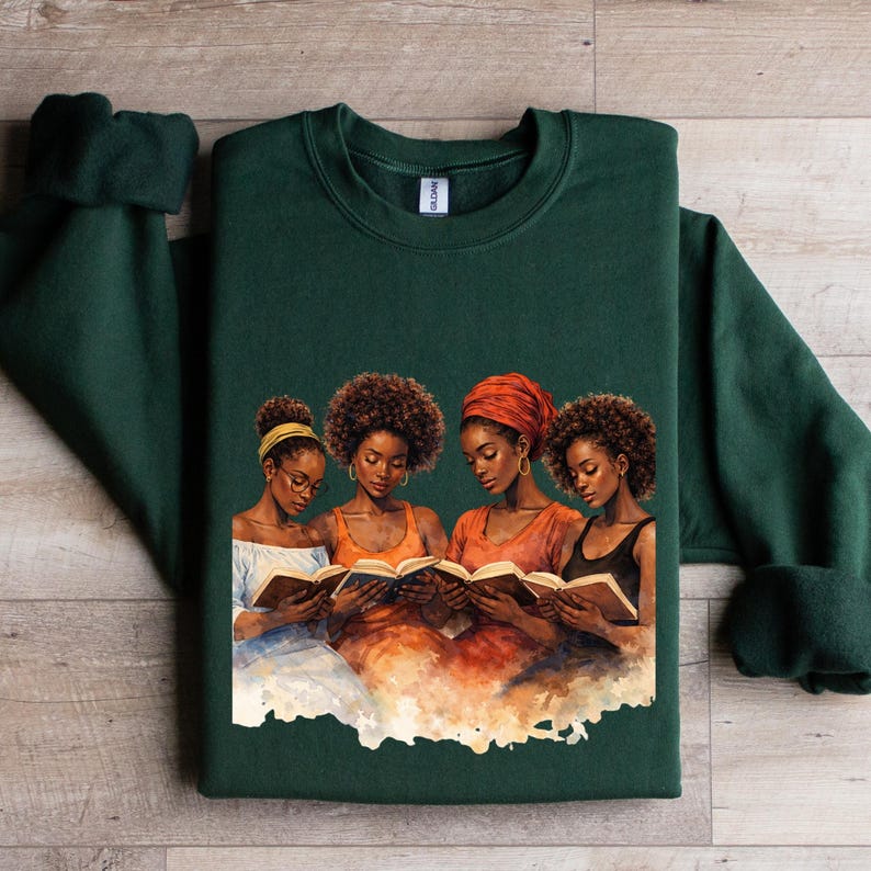 Puede incluir: Una sudadera verde oscuro con una ilustraci&oacute;n de acuarela de cuatro mujeres leyendo libros. Las mujeres est&aacute;n representadas con varios peinados y ropa, con tonos c&aacute;lidos de naranja y marr&oacute;n. La sudadera est&aacute; hecha de un material suave.