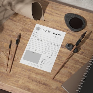 May include: A blank order form with sections for customer information, order details, payment method, and totals. The form is on a wooden table with a black inkwell and two paintbrushes.