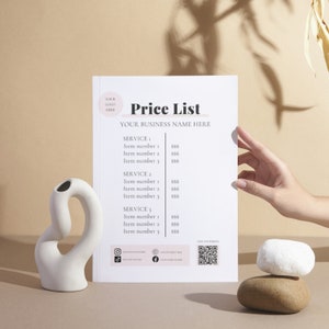May include: A white price list with the text "Price List" and "Your Business Name Here" at the top. The list includes services and prices for each item. The list is on a beige surface with a white vase and two rocks.