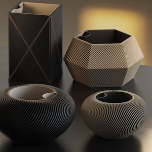 Pode incluir: Uma coleção de quatro vasos decorativos modernos em tons de preto e bege. Os vasos variam em forma, incluindo um quadrado alto, um hexágono geométrico e duas tigelas arredondadas. Cada vaso apresenta um design canelado.