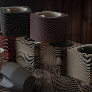 Puede incluir: Una colección de macetas modernas y geométricas en varios colores, incluyendo negro, rojo y beige. Las macetas tienen un diseño único con estrías y una abertura circular en la parte superior. Algunas tienen un recipiente a juego separado.