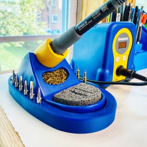 May include: Blue soldering station with a soldering iron, sponge, and a variety of tools. The station has a digital display that reads "31818".