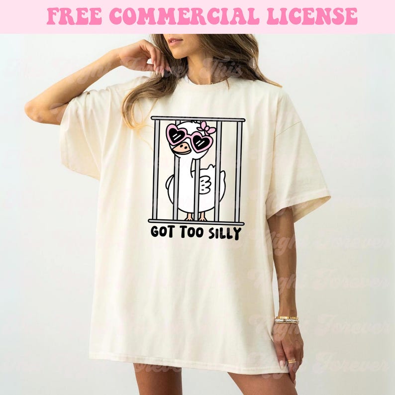 May include: A white t-shirt with a cartoon illustration of a duck wearing heart-shaped sunglasses and a flower in its hair. The duck is in a cage and the text "GOT TOO SILLY" is printed below the image.