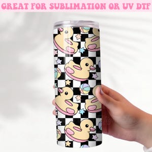 May include: A stainless steel tumbler featuring a repeating pattern of yellow rubber duckies, pastel stars, and colorful balls on a black and white checkered background. The text "GREAT FOR SUBLIMATION OR UV DTF" is at the top.