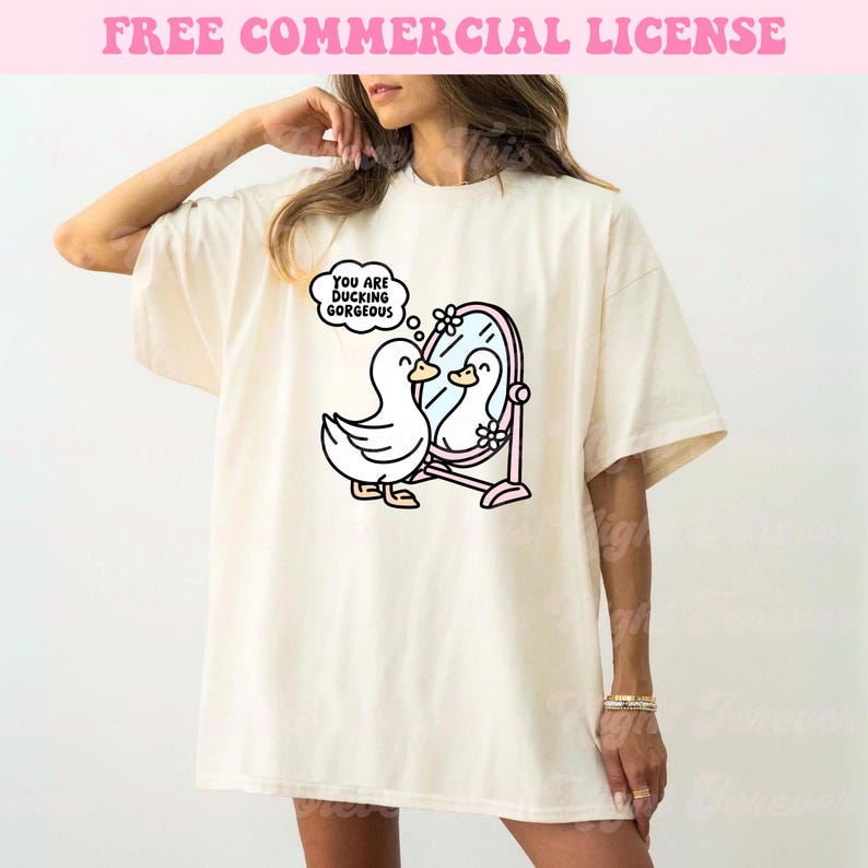 K&ouml;nnte beinhalten: Ein wei&szlig;es T-Shirt mit einer Comic-Ente, die in einen Spiegel schaut. Die Ente sagt "You are ducking gorgeous".