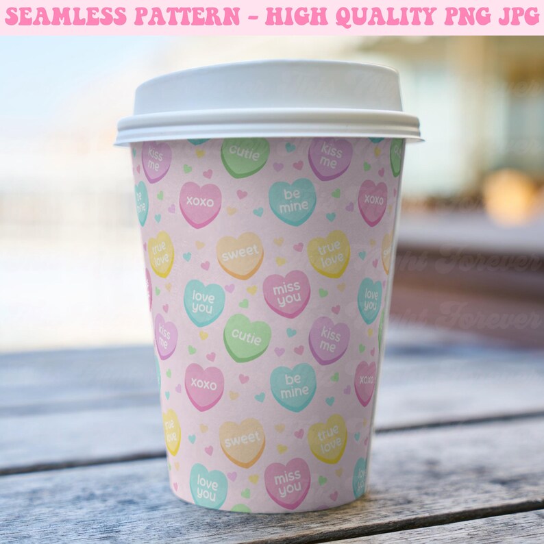 May include: A pink paper cup with a repeating pattern of pastel-colored candy hearts with various messages, including "love you", "miss you", "kiss me", "be mine", "true love", "sweet", "cutie", and "xoxo".