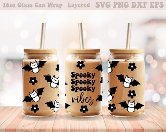 May include: Three 16oz glass can wraps with a Halloween theme. The wraps feature black bats with white faces, black flowers, and the text "Spooky Spooky Spooky vibes".