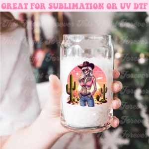 May include: A clear glass can-shaped cup with a colorful graphic of a skeleton cowgirl in a pink shirt, blue jeans, and a cowboy hat, standing in front of a desert scene with cacti. Text at the top reads "GREAT FOR SUBLIMATION OR UV DTF".