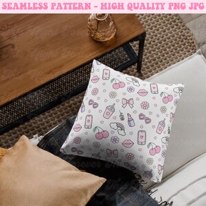 May include: A white pillow with a pink and white pattern of cherries, lips, sunglasses, rainbows, and other cute designs. The pillow is on a couch with a brown wooden table and a tan rug.