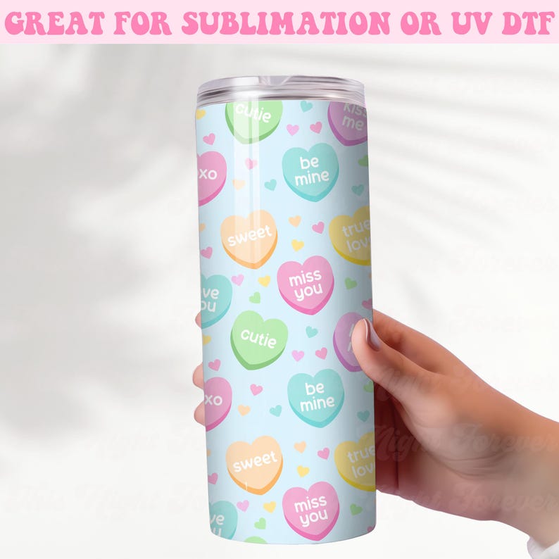 May include: A light blue stainless steel tumbler with a pattern of colorful candy hearts. The hearts have various messages on them, including "miss you", "be mine", "cutie", "sweet", "true love", and "kiss me".