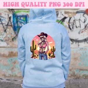 May include: Light blue hoodie with a graphic of a skeleton cowgirl in a desert scene. The design features a cowgirl skeleton wearing a pink top, jeans, and a cowboy hat, with cacti and a sunset in the background. Text at the top reads "HIGH QUALITY PNG 300 DPI."
