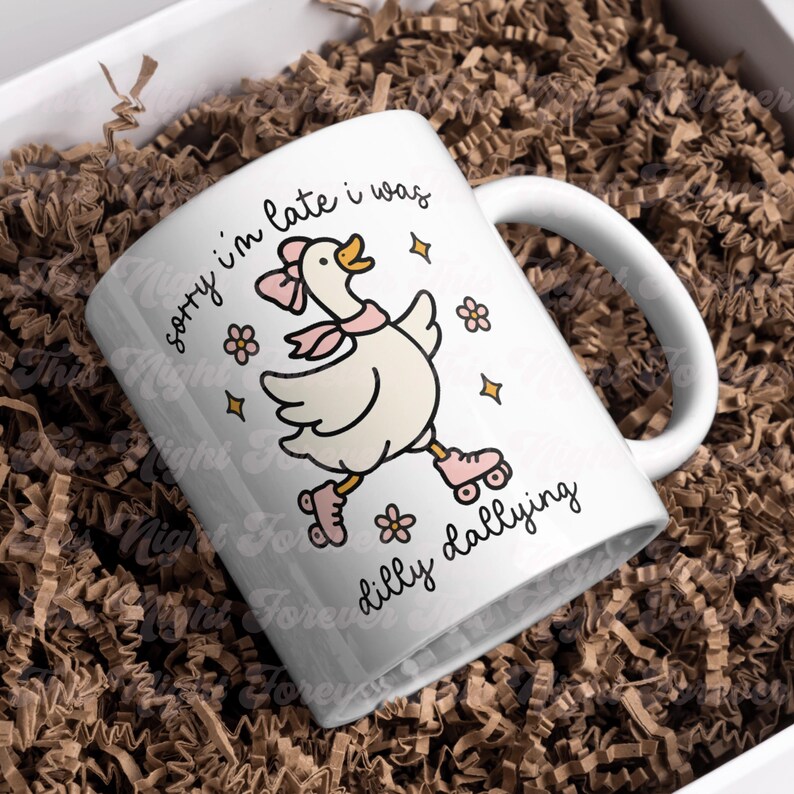 K&ouml;nnte beinhalten: Wei&szlig;e Keramiktasse mit einer Cartoon-Gans, die einen rosa Schal und Rollschuhe tr&auml;gt. Auf der Tasse steht der Text "sorry I'm late I was dilly dallying" in schwarzer Schrift, mit Blumen- und Sternakzenten.