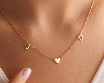 May include: A gold necklace with a heart charm and two initial charms. The initials are "J" and "D".