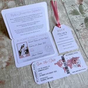 May include: A pink and white save the date card with a passport and boarding pass design. The card features a photo of a couple, a world map, and the text "Save the Date" for the wedding of Hannah & Scott on Saturday, August 6th, 2022 in Algarve, Portugal.
