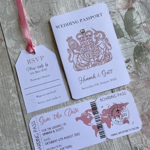May include: A white wedding invitation set with a pink ribbon. The invitation features a passport design with a royal crest and the text "Wedding Passport". The RSVP card has a luggage tag design with the text "RSVP" and "Please reply by 6th May 2022". The save the date card has a boarding pass design with the text "Save the Date" and "Hannah & Scott".