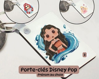 Puede incluir: Un llavero blanco con una imagen de dibujos animados azul y blanco de una princesa Disney con el pelo largo y negro. El llavero tiene un anillo plateado y un lazo de plástico transparente. El texto "Porte-clés Disney Pop" y "Prénom au choix" está impreso en el llavero.