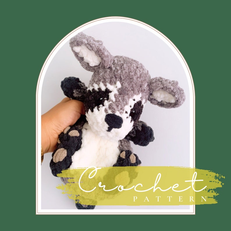 May include: Crocheted raccoon amigurumi toy with gray and white fur, black eyes, and a black nose. The toy is being held by a hand. The image has the text "Crochet Pattern" on a yellow background.