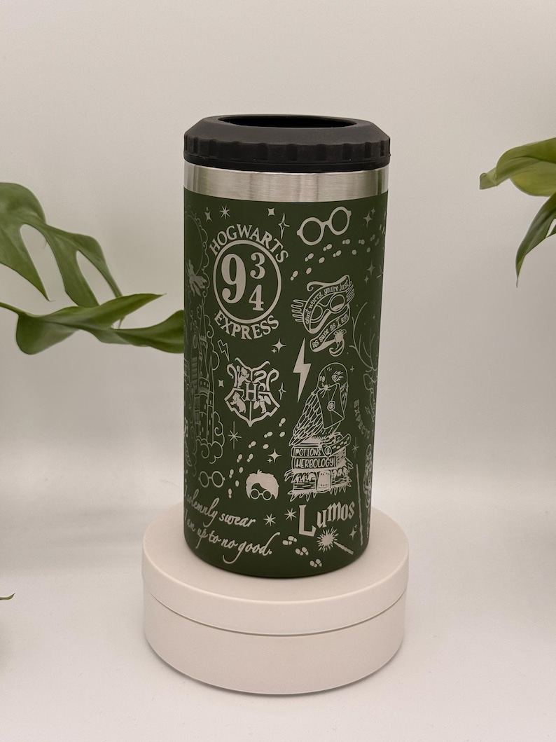 May include: Green insulated can cooler with a black top. The cooler is decorated with white illustrations of the Hogwarts Express logo, glasses, a lightning bolt, an owl, and the word "Lumos". The text "Hogwarts Express" is also visible.