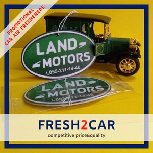 May include: Green and white oval car air fresheners with the text "LAND MOTORS" and a phone number, next to a green vintage car model. The words "PROMOTIONAL CAR AIR FRESHENERS" are printed on the left side.