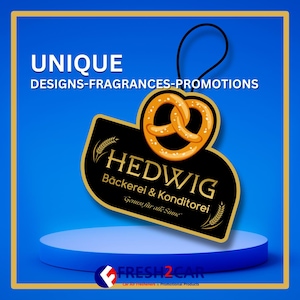 May include: A black and gold car air freshener with a pretzel design and the text "HEDWIG Bäckerei & Konditorei Genuss für alle Sinne".