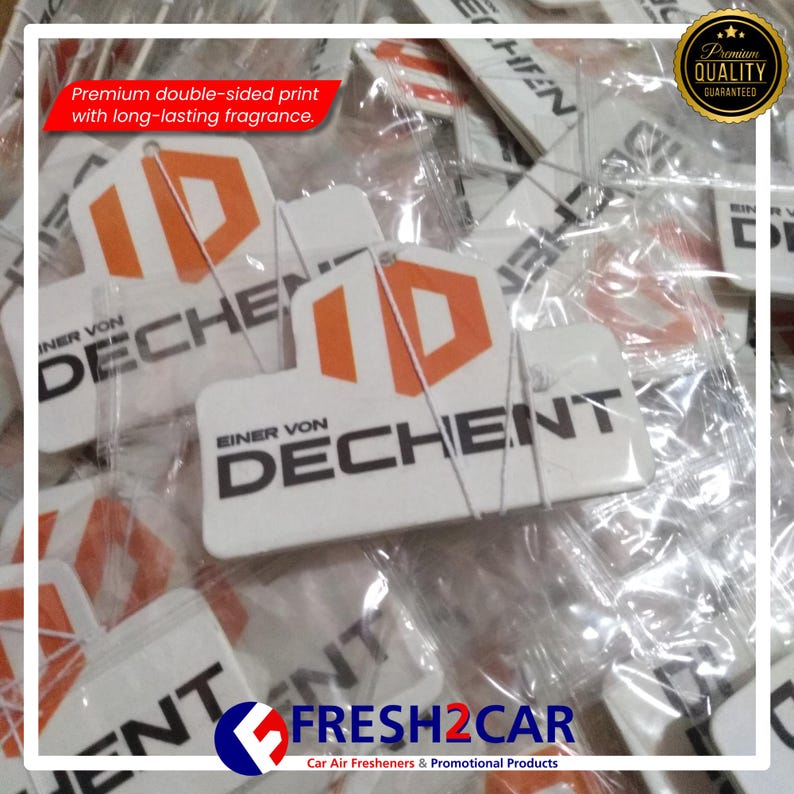 Pu&ograve; includere: Profumatori per auto bianchi con un logo arancione e bianco che recita "ID DECHENT". &Egrave; visibile anche il testo "Stampa fronte-retro premium con fragranza a lunga durata". I profumatori sono confezionati in plastica trasparente.